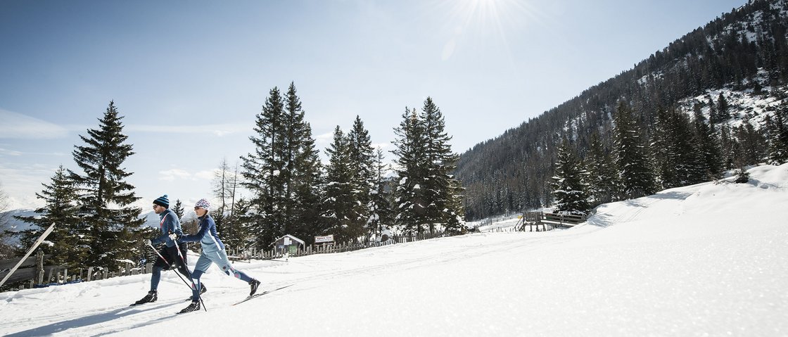 That little extra on your ski holiday in Stubaital Two cross-country skiers on snow under bright blue sky with mountains in background