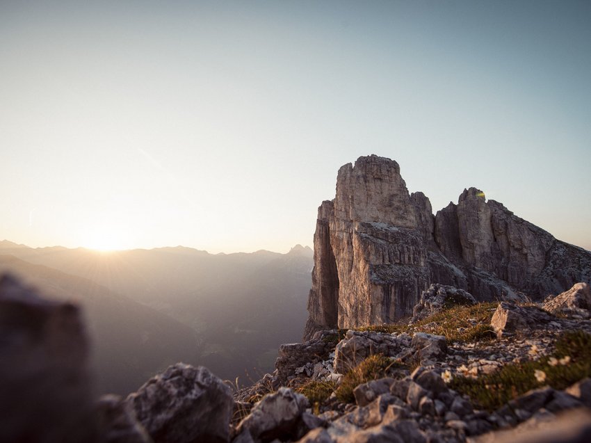 Bereit für Ihren Urlaub im Stubaital im Sommer? Sonnenaufgang über felsigem Berggipfel mit klarem Himmel