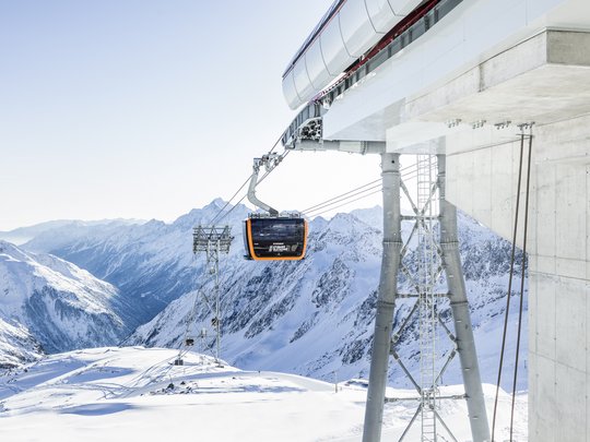 Dreaming of skiing? Head to our ski hotel in Stubaital! Gondola lift in snowy mountain landscape with peaks in the background