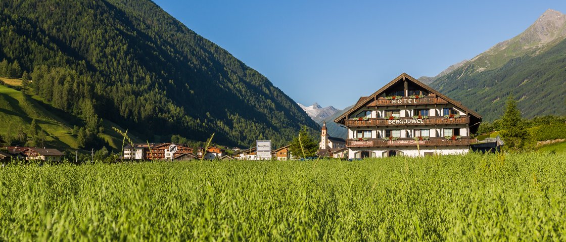 Recharge at our hotel in Neustift im Stubaital, Austria Hotel in a green valley with mountains and clear blue sky in the background
