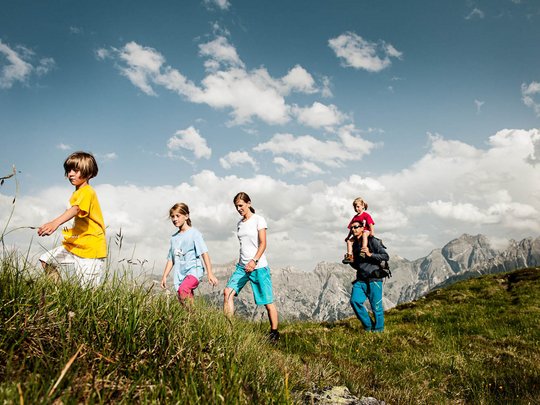 Qualitätszeit im Familienhotel im Stubaital Familie wandert mit Kindern in den Bergen bei sonnigem Wetter