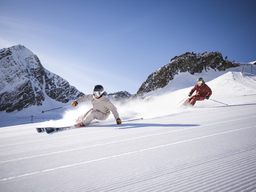 Aktivtipps für Ihren Urlaub im Stubaital Zwei Skifahrer auf frisch gespurtem Schnee vor Bergkulisse bei Sonnenschein