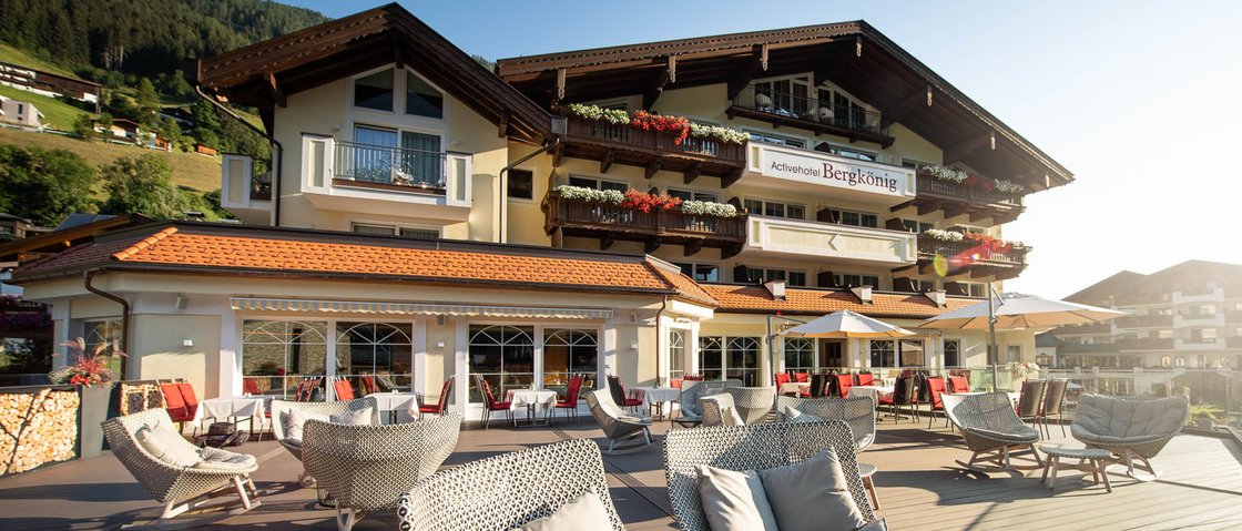 Recharge at our hotel in Neustift im Stubaital, Austria Terrace with chairs in front of alpine hotel in sunny mountain landscape